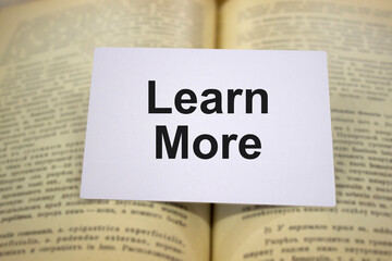 Learn more written in white note on open books