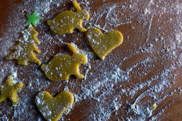 Shortbread cookies of different shapes on a wooden table with flour. Cooking, baking.