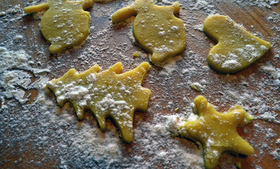 Shortbread cookies of different shapes on a wooden table with flour. Cooking, baking.