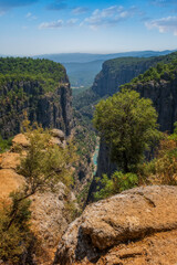 Fototapeta na wymiar The canyon between the two mountains, which are shaped as horns, which the people of the region call the 'Tazi Canyon', reveals the view of Köprüçay under the feet. August 2020