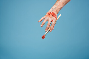 Artists hands paint close-up blue background drawing hobby
