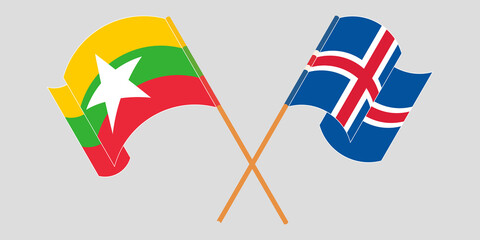 Crossed and waving flags of Myanmar and Iceland