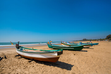 Naklejka na ściany i meble Idyllic scene at South Asia (India ): fishing boats on the sand and beach of Indian Ocean
