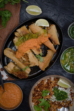 Fried Vegan Tamales In Cast Iron Serving Plate Along With Ranchero Sauce And Chili Cilantrio Salsa