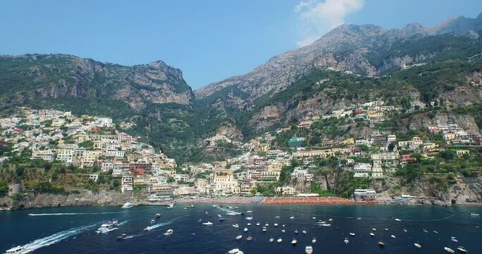 Mountains tower over Amalfi Coast town, wide aerial