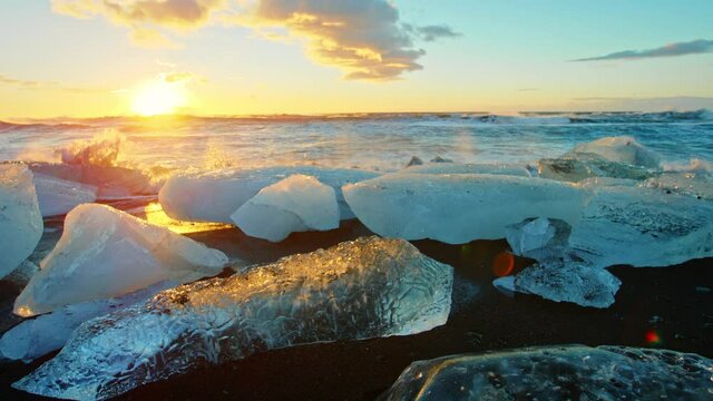 Slow motion, Okulsarlon Beach covered in ice at sunset