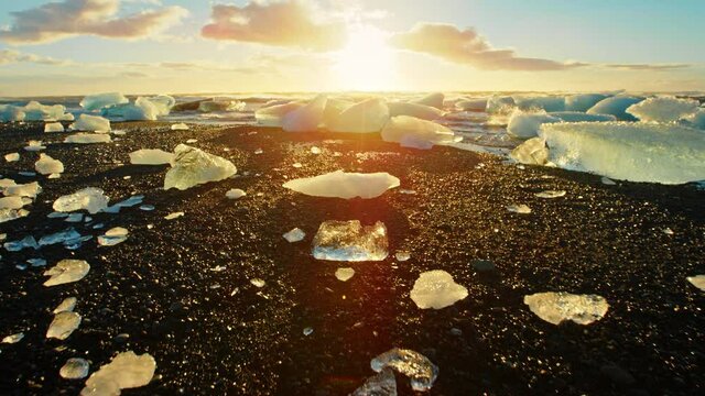 Low angle, sun sets over ice on Iceland beach