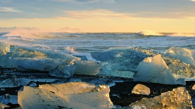 Slow motion close up, icebergs on beach in Iceland at sunset