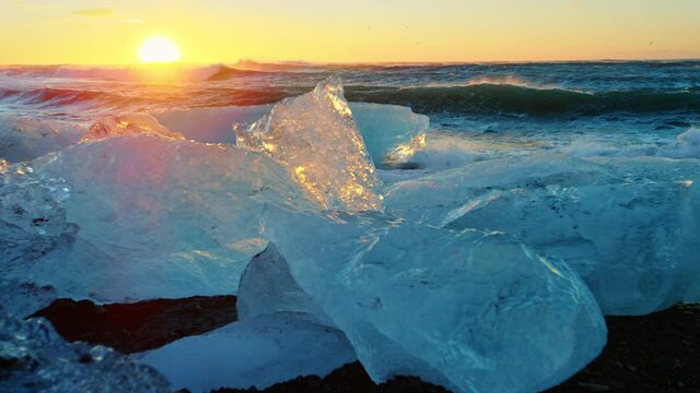 Slow motion close up, Iceland beach covered in ice at sunset