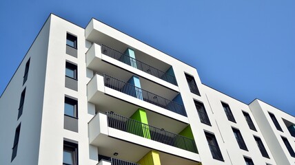 Contemporary residential building exterior in the daylight. Modern apartment buildings on a sunny day with a blue sky. Facade of a modern apartment building