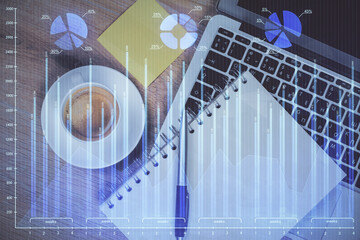Double exposure of forex chart drawing over table background with computer. Concept of financial research and analysis. Top view.