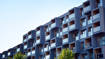 Contemporary residential building exterior in the daylight. Modern apartment buildings on a sunny day with a blue sky. Facade of a modern apartment building