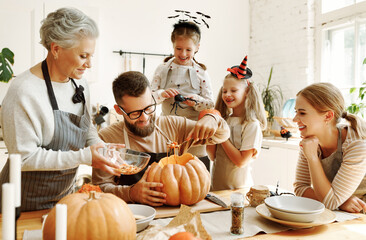 Family carving pumpkin for Halloween celebration.