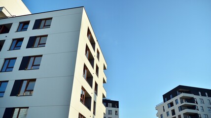 Contemporary residential building exterior in the daylight. Modern apartment buildings on a sunny day with a blue sky. Facade of a modern apartment building