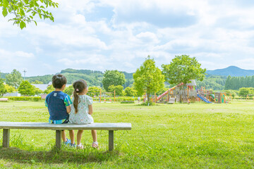 公園でのんびりする男の子と女の子 - obrazy, fototapety, plakaty