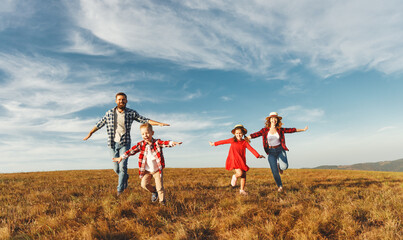 Happy family: mother, father, children son and daughter on sunset.