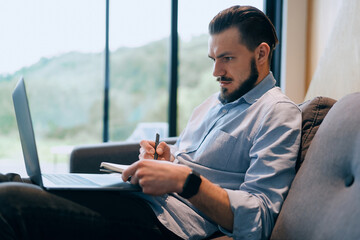 Side view of tired business man sitting at a home after a hard workday