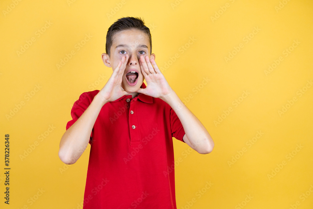 Wall mural young beautiful child boy over isolated yellow background shouting and screaming loud to side with h