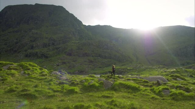Panning aerial, backpacker in Ireland countryside