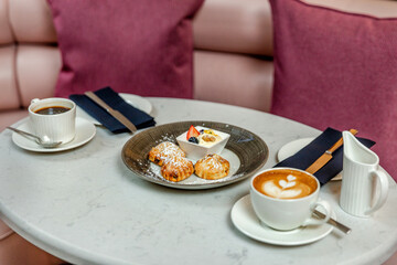 Latte art and scones on the table for afternoon tea
