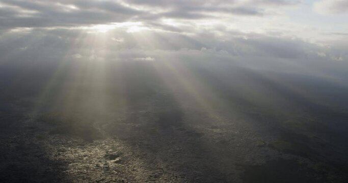 Sun shines over volcanic coastline, aerial