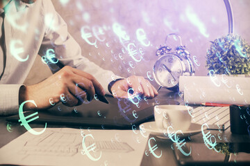 Double exposure of man's hands holding and using a phone and financial graph drawing. Analysis concept.