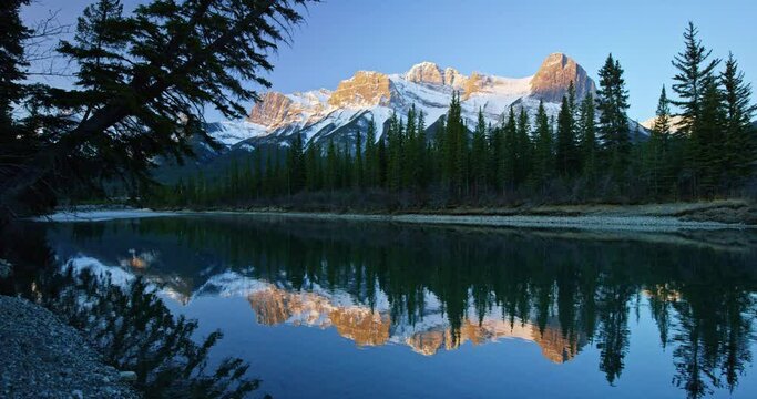 Mountains reflect off creek in Banff National Park, low angle