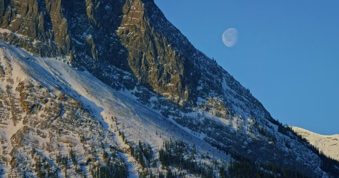 Full moon over mountains in Banff National Park, low angle