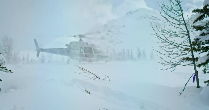 Low angle, helicopter takes off in snowy Banff National Park landscape