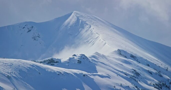 Wide aerial, snowy mountain range in Banff National Park