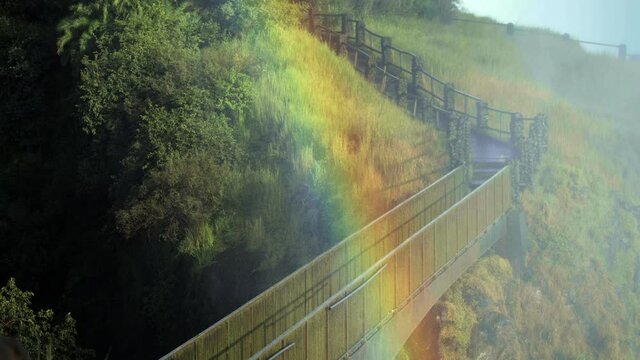 Medium shot, Victoria Falls rainbow over hiking trail