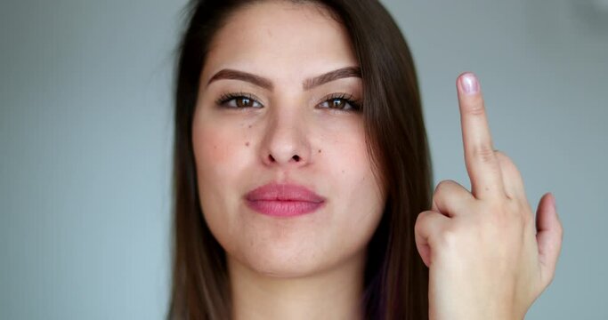 Offended woman shows middle finger at camera, portrait face girl gestures to go away