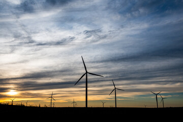 Sunset behind a field of wind turbines