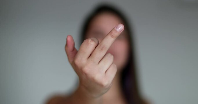 Offended woman shows middle finger, angry upset girl flipping finger