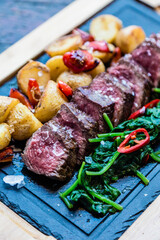 Beef with baked potatoes and vegetables. Food in the Mediterranean of the island of Majorca.