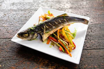 Fried fish on a mattress of grilled vegetables. Mediterranean food from the island of Majorca.