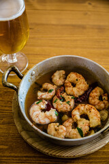 Garlic shrimp in metal casserole.