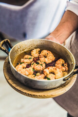 Garlic shrimp in metal casserole.