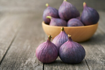 three ripe figs on a rustic background, with copy space.