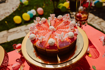 Cute pink table for a summer party in the yard. Pink cakes and treats on the table