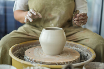 Fototapeta na wymiar Woman making pottery on the wheel