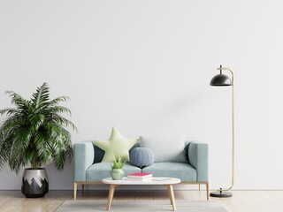 Empty living room with blue sofa, plants and table on empty white wall background.