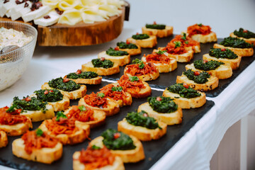 Small canapes sandwiches served on a plate at the celebration. Snack for guests