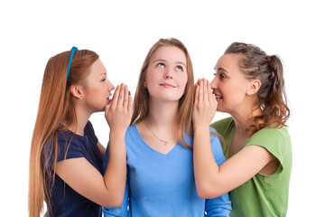 Three Young Caucasian Girlfriends Sharing Their Secrets Whispering to Ears.Isolated Over White Background.