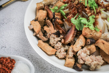 Close up tofu,bean sprout,sausage,crab stick and coriander in Chinese Steamed Rice Noodles with sweet soy sauce in white plate.Asian food concept.
