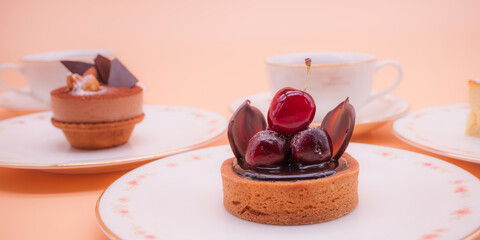 ケーキやタルトなどたくさんのお菓子が並んだティーパーティ