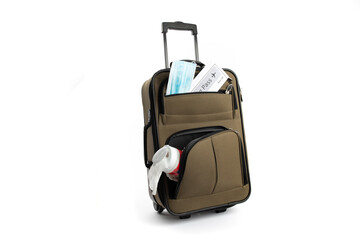a surgical mask, a boarding pass, and a package of disinfecting wipes in a suitcase suggesting the new normal for air travel after covid-19 
