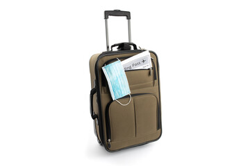 a surgical mask and a boarding pass in a carry on suitcase suggesting the new normal for air travel after covid-19 coronavirus pandemic