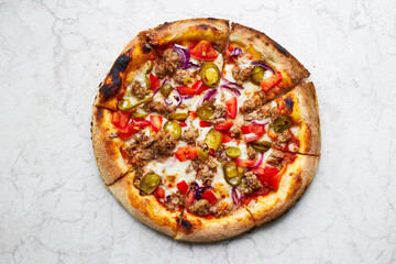 Traditional spicy italian pizza with jalapeno peppers cooked in a wood-fired oven