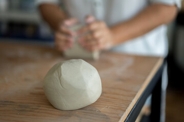 Woman kneading clay to make pottery